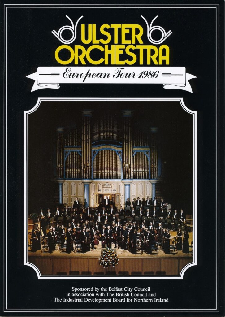 Poster for the Ulster Orchestra European Tour 1986 featuring a group photo of the orchestra seated on stage in front of a large pipe organ at the renowned Musikverein Golden Hall.