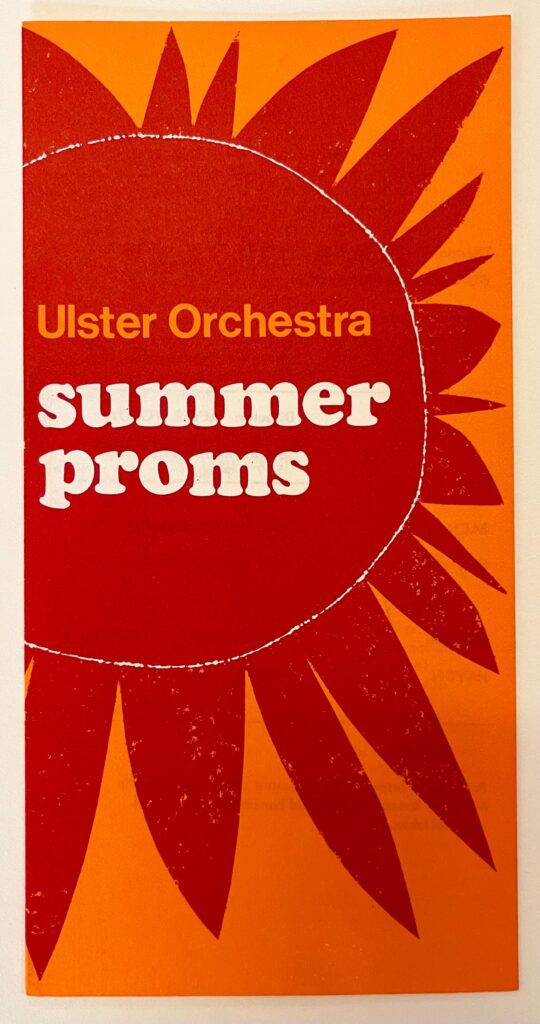 Front cover of the Ulster Orchestra Summer Proms programme, featuring an illustration of a red sun over an orange background